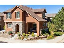 Inviting two-story home featuring a charming stone-accented entry and well-maintained landscaping at 10654 Ashfield St, Highlands Ranch, CO 80126