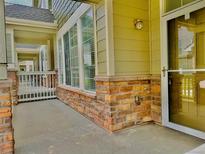Inviting covered front porch with stone accents and a modern glass storm door entry at 15955 E Geddes Dr # 55, Aurora, CO 80016