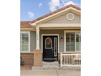 Charming home featuring a welcoming front door with decorative wreath and brick accents at 1410 Exquisite St, Castle Rock, CO 80109