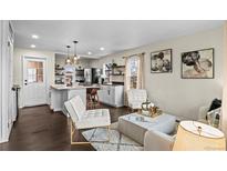 A bright living room open to the kitchen with wood floors and contemporary furnishings at 2020 Gray St, Edgewater, CO 80214