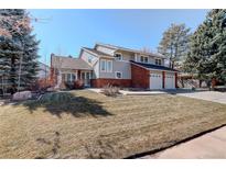 Charming two-story home with a brick and gray facade, mature trees, and a well-maintained lawn at 9526 E Lake Ave, Greenwood Village, CO 80111