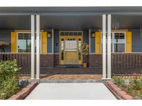 Inviting front entrance with a decorative yellow door and brick accents leading to a cozy porch at 3967 Eastout Ave, Parker, CO 80138