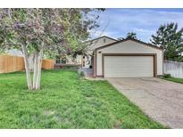 Charming home featuring a well-manicured lawn, mature trees, and an attached two-car garage at 4483 S Eagle Cir, Aurora, CO 80015