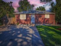 Charming brick home with a well-manicured lawn, concrete driveway, and inviting front entrance at 1731 Uinta St, Denver, CO 80220