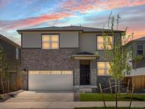Beautiful two-story home featuring stone accents, a two-car garage, and a well-manicured lawn at 6068 Hourglass Dr, Brighton, CO 80601