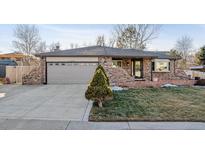 Charming brick home featuring a well-maintained lawn and a two-car garage at 13215 Peacock Dr, Lone Tree, CO 80124