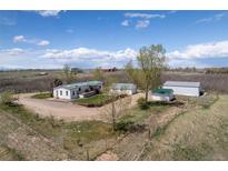 Sprawling property featuring a charming home with a green roof, outbuildings, and scenic surroundings at 17445 County Road 6, Brighton, CO 80603