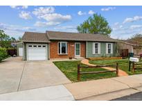 Charming home with brick accents, attached garage, and a walkway to the front door at 8625 W Dartmouth Pl, Lakewood, CO 80227
