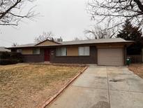 Ranch style home with attached garage and well-manicured lawn at 440 Empire St, Aurora, CO 80010