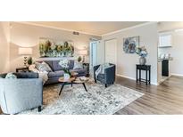 Cozy living room features modern furniture, neutral decor, and wood-look flooring for comfortable living at 10211 Ura Ln # 1-308, Thornton, CO 80260