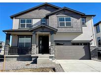 Charming two-story home with a gray color scheme, stone accents, and a covered front porch at 545 Twilight St, Erie, CO 80516