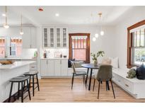 Bright dining area features a built-in bench, modern light fixture, and seamless flow to the kitchen at 3361 W 36Th Ave, Denver, CO 80211