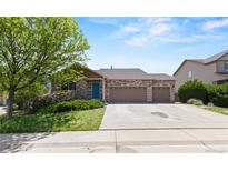 Charming single-Gathering home featuring a 3-car garage, manicured lawn, and stone accents at 6760 E 129Th Ave, Thornton, CO 80602