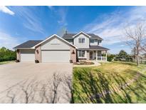 Charming two-story home featuring a spacious three-car garage and well-maintained front yard at 29145 E 160Th Ct, Brighton, CO 80603