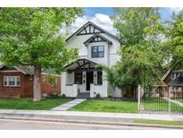 Charming two-story home featuring black and white trim, manicured lawn, and inviting walkway at 451 S Franklin St, Denver, CO 80209