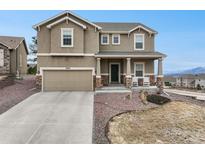 Charming two-story home with a well-manicured front yard, covered porch, and an attached two-car garage at 19703 Serenity Springs Pt, Monument, CO 80132