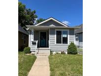 Charming single-story home with light gray siding, a small porch, and well-kept front lawn at 4875 Lowell Blvd, Denver, CO 80221