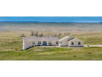 Charming ranch-style home with a sprawling lawn and mountain views at 5129 S Tom Bay Rd, Bennett, CO 80102