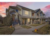 Charming townhouse featuring a stucco facade, tiled roof, and inviting front entrance with stone accents at 22520 E Ontario Dr # 101, Aurora, CO 80016