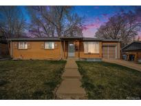 Charming brick home with a well-maintained lawn and attached garage at 3937 W Grand Ave, Littleton, CO 80123
