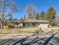 Charming ranch-style home with mature trees, attached garage, and front yard at 7329 S Jay St, Littleton, CO 80128