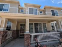 Inviting front porch with brick accents and white railing, perfect for relaxing outdoors at 16051 E Geddes Dr # 66, Aurora, CO 80016