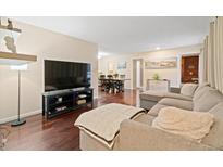 Open-concept living area featuring hardwood floors, comfortable seating, and adjacent dining space at 2306 S Troy St # A, Aurora, CO 80014