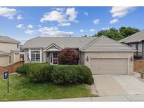 Charming single-story home with a well-manicured lawn, a two-car garage, and beautiful landscaping at 3305 White Oak Ln, Highlands Ranch, CO 80129