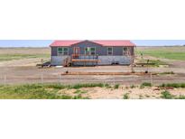Charming single-story home featuring a red roof, welcoming front porch, and well-maintained landscaping at 41575 E 88Th Ave, Bennett, CO 80102