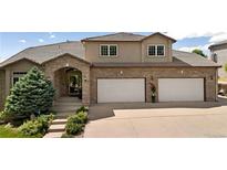 Elegant two-story home featuring a brick and stucco facade, well-manicured landscaping, and a spacious two-car garage at 2595 S Harlan Ct, Lakewood, CO 80227