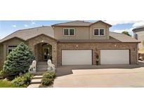 Stunning home featuring a brick and stucco exterior with a well-manicured front yard and a two car garage at 2595 S Harlan Ct, Lakewood, CO 80227