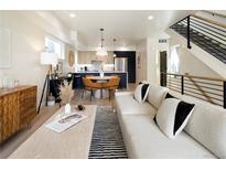 Open-concept living room with modern furnishings and seamless flow to kitchen and staircase at 1260 N Stuart St # 2, Denver, CO 80204