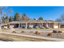 Charming red brick ranch-style home with manicured landscaping and a circular driveway at 3580 S Dahlia St, Denver, CO 80237