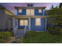Charming two-story home with a blue exterior, inviting front porch, and well-maintained lawn at 4689 Tanner Peak Trl, Brighton, CO 80601
