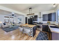 Open floor plan featuring a modern kitchen with stainless steel appliances and a decorative center island at 4689 Tanner Peak Trl, Brighton, CO 80601