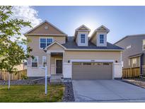 Charming two-story home with a two-car garage and well-maintained front yard with grass and rock at 9099 Sedalia St, Commerce City, CO 80022