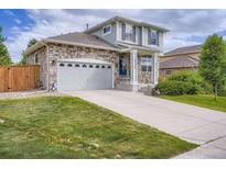Charming two-story home featuring a stone facade, a well-manicured lawn, and a two-car garage at 24748 E Layton Pl, Aurora, CO 80016
