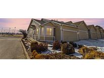 Inviting exterior view of a townhome with an attached garage and well-maintained landscaping in a suburban neighborhood at 12292 E 2Nd Dr, Aurora, CO 80011