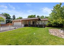 Charming home featuring a lush green lawn and lovely white picket fence at 4627 S Norfolk Way, Aurora, CO 80015