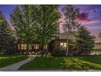 Charming brick home with a welcoming front entrance and well-manicured lawn at 6940 Saddleback Ave, Firestone, CO 80504