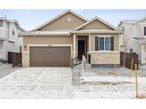 Charming single-Gathering home featuring a stone-accented facade and attached two-car garage at 9673 Ceylon St, Commerce City, CO 80022