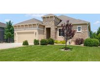 Charming one-story home with a manicured lawn, stone accents, and a two-car garage at 15779 W 83Rd Pl, Arvada, CO 80007