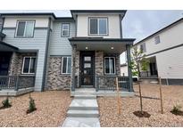 Inviting two-story home with stone accents, covered porch, and well-maintained landscaping at 6678 N Nepal Ct, Aurora, CO 80019