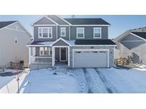 Two-story house with gray siding, stone accents, and a two-car garage at 39260 Braxton Ln, Elizabeth, CO 80107