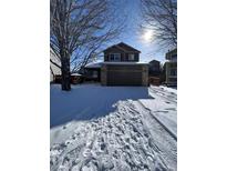 Charming two-story home featuring a two-car garage, a welcoming front porch, and a snow-covered yard at 3610 Morning Glory Dr, Castle Rock, CO 80109