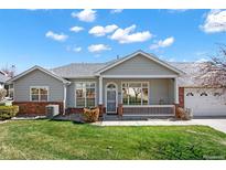 Inviting single-story home featuring a charming front porch and a well-manicured lawn at 3231 E 102Nd Pl, Thornton, CO 80229