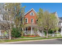 Charming brick home with a inviting front porch and manicured lawn, perfect for relaxing at 2831 Spruce St, Denver, CO 80238