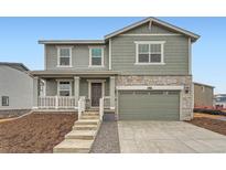 Charming two-story home with sage green siding, stone accents, and a covered front porch at 22077 E 39Th Pl, Aurora, CO 80019