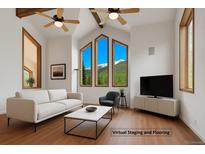 Bright living room with vaulted ceilings, wood beams, and mountain views from the beautiful, large picture windows at 322 Davis Ct, Breckenridge, CO 80424