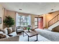 Cozy living room featuring neutral tones, plush seating, and large window with natural light at 431 S Balsam St, Lakewood, CO 80226